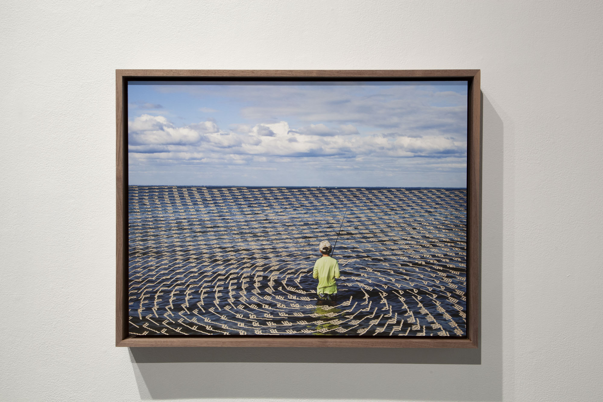 A child fishing in the ocean with a hurricane's wind map superimposed over the water